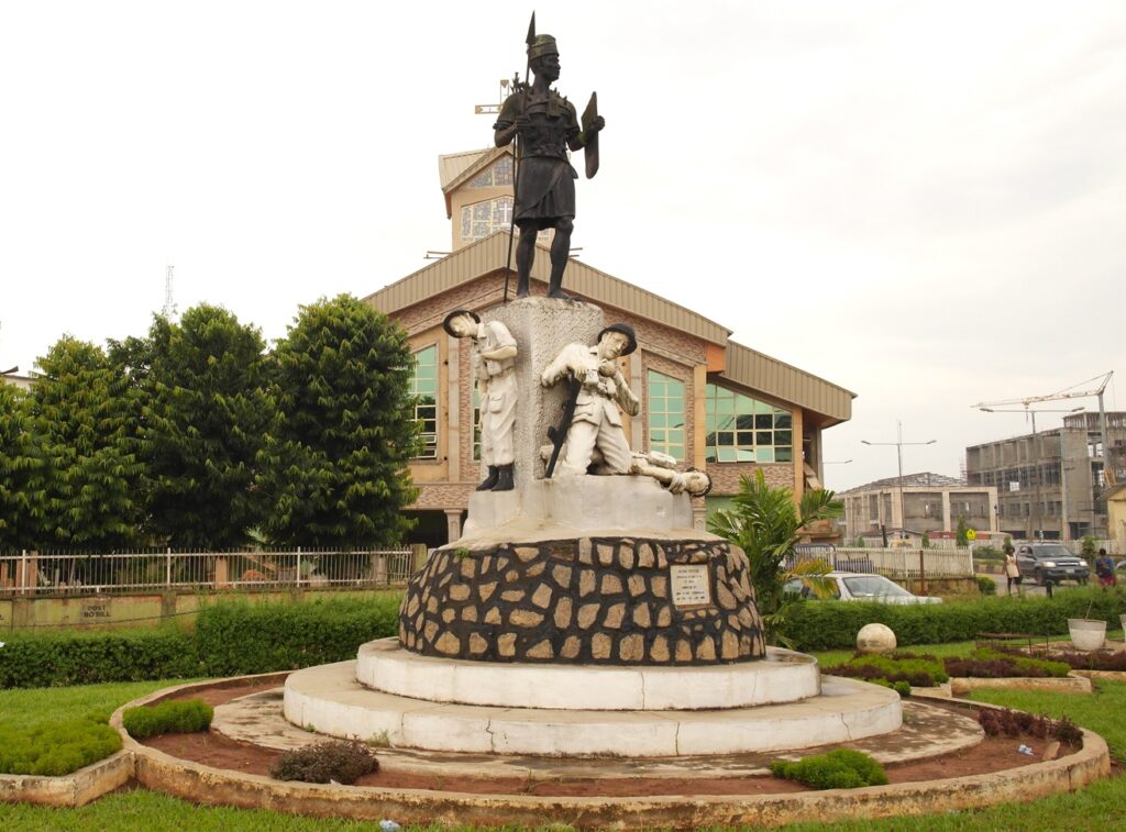 King' Square, Benin City, Nigeria: Benin soldier hovering above dead British conquerors